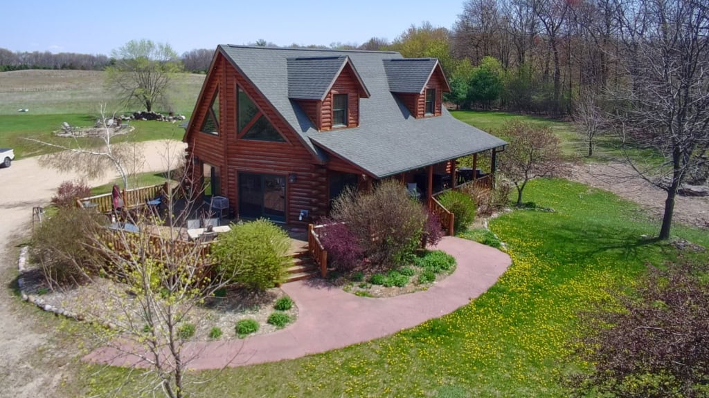 Beautiful log cabin surrounded by trees and greenery in Wisconsin.